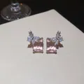 Dettaglio macro di eleganti orecchini a perno rettangolari rosa con ali di farfalla in zircone - Solo Orecchini / Argento-Rosa