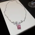Gros plan d'un collier en zircon rose avec des détails floraux délicats sur boîte blanche. - Ensemble Collier + Boucles d'Oreilles / Argent-Rose