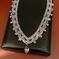 Elegant vintage beaded lace necklace with sparkling teardrop crystals on a black gift box. - Gray