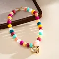 Detail shot of colorful marbled acrylic bead necklace with large gold heart pendant - Necklace-Multicolor