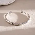 Macro-detail van een zilveren C-vormige armband met geometrische diamantgeslepen textuur. - Ruitpatroon Stijl / Zilver