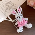 Vue détaillée d'un collier de lapin en perles fait main avec un nœud en ruban - Lapin / Blanc Rose