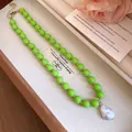 Detailed view of vibrant green beaded necklace featuring a white baroque pearl pendant - Green