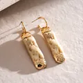 Close-up detail of irregular resin faux stone earrings with a hammered gold-tone metal finish - Stud Pin Style / Gold-White (HE34427)