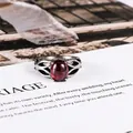 Vintage stainless steel ring with a large oval red gemstone and hollow leaf design - US 6 / Red