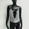 Primer plano de un sexy top halter de malla metálica plateada en un maniquí negro - S / Tops / Plateado