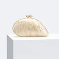 Close-up detail of asymmetric acrylic evening clutch bag with pearlescent marble texture - Apricot