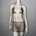 Détail d'un ensemble haut licou en maille pailletée et mini-jupe avec chaînes de taille étagées - Couleur caramel