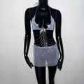Détail de l'ensemble haut licou et mini-jupe bleu clair avec strass et chaînes - Bleu clair