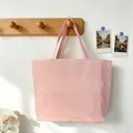 Pink and white striped tote bag hanging on a wooden rack in a lifestyle setting - Rose Pink