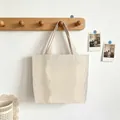 Striped canvas tote bag hanging on a wooden wall hook for a stylish storage display. - Khaki