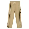 Dettaglio dei pantaloni sportivi cachi da uomo con bottoni a pressione laterali e strisce. - S / Bottoms / Cachi