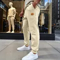 Ανδρικό μπεζ παντελόνι jogger ζακάρ με ανάγλυφο σχέδιο και κομψό δερμάτινο σήμα στη λεπτομέρεια - S / Bottoms / Βερικοκί