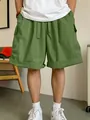 Vista dettagliata dei pantaloncini cargo verdi da uomo con multitasche sul modello - S / Bottoms / Verde