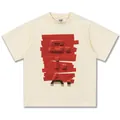 Schweres cremefarbenes Baumwoll-T-Shirt mit einem einzigartigen roten 3D-Klebeband-Design. - S / Tops / Creme