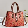 Close-up detail of cherry print and gold hardware on a stylish brown leather bag - 30*12*23 / Earthy Yellow