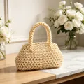 Dettaglio borsa fatta a mano con perle color crema su tavolo di marmo e rose - Piccola Borsa Quadrata Intrecciata Bianco Crema