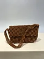 Dettaglio della trama di perline di legno intrecciate a mano di questa borsa marrone. - Borsa a Patta Rettangolare Marrone Scuro