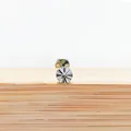 Premium silver F136 titanium labret stud with sunburst pattern head on wood surface - Style 3 Silver / 1.2x6mm M0.9 Teeth