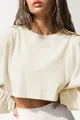 Close-up van een crème cropped sweatshirt met lange mouwen en ronde hals met textuur. - Abrikoos