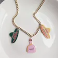 Gros plan d'un collier en acrylique Cinco de Mayo avec des breloques sombrero et téquila - Style Sombrero et Bouteille de Tequila