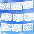 Gros plan de bannières mexicaines Papel Picado blanches suspendues sous un ciel bleu - Style Coeur Soleil Blanc