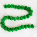 Detailed macro view of a long green plastic marigold pom-pom garland for festive party decor - No.16 Green