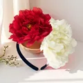 Close-up detail of oversized 12cm red and white artificial camellia flower bridal headband - Bright Red And White (FG215-8)