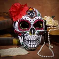 Detailansicht einer Tag der Toten Maske mit einer roten Blume und Vintage-Requisiten. - Rote Blume Stil