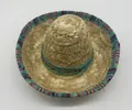 Detailed view of a miniature straw sombrero with a colorful ethnic geometric fabric trim. - Natural Straw Colorful Geometric Style (32) / Headband Style