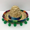 Primo piano di un mini cappello di paglia messicano con bordo colorato e pon pon. - Misura 5