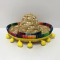 Macro view of a mini Mexican straw sombrero featuring colorful trim and yellow pom-poms - Size 4 / Headband Style