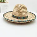 Detail view of handmade Mexican straw hat with vibrant ethnic geometric patterned trim. - Natural With Blue Ribbon