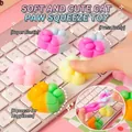 Juguete antiestrés blandito con forma de pata de gato colorido sobre un teclado blanco. - Garra de Gato Colorida