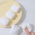 Detailopname van een wit tofu-vormig squishy speeltje met een slow-rebound effect. - Water Tofu