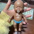 Funny brown baby ugly doll decompression toy figure with blue diaper and clear pacifier - 14cm Bubble-blowing Black Doll