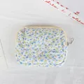 Detailed macro view of a floral quilted mini pouch with a snap flap and zipper closure - Light Blue Flower