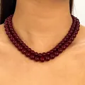 Detail view of a glossy double-strand burgundy beaded necklace on a model's neck - Layered Double Layer (Pack of 2) / Burgundy
