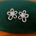 Primo piano di orecchini a lobo a forma di fiore cavo in argento con zirconi - Stud orecchini / Argento