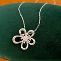 Primo piano di un'elegante collana con ciondolo a fiore traforato in finitura argento lucido. - Collana / Argento