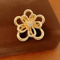 Dettaglio ravvicinato di un ciondolo a fiore traforato placcato oro 18k con zirconi chiari - Spilla / Oro