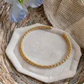 Dettaglio macro che mostra l'elegante design a corda d'oro di questa collana choker. - Choker Aperto Texture a Rete (1) / Oro
