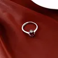Gros plan d'une bague en argent minimaliste sertie d'un zircon ovale rouge foncé. - Violet