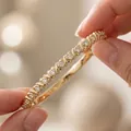 Detailed macro view of an elegant gold-plated stainless steel bangle set with clear stones - Gold Rhinestone Style / Gold