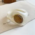 Gros plan d'un bracelet jonc en acrylique marbré avec incrustation d'ambre ovale - Style Géométrique Ouvert (4#) / Blanc Cassé-Café