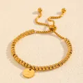Close-up of adjustable gold titanium steel beaded bracelet featuring a letter D disc charm - Letter D Style (238224) / Gold