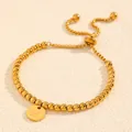 Détail d'un bracelet en perles d'acier titane doré avec un pendentif lettre H gravé. - Style Lettre H (238224) / Or