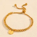 Détail en gros plan d'un bracelet en perles d'acier titane doré avec breloque lettre R - Style Lettre R (238224) / Or