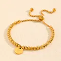 Gros plan d'un bracelet en perles d'acier titane doré avec breloque initiale 'Y' gravée - Style Lettre Y (238224) / Or