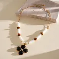 Vista dettagliata di una collana vintage con ciondolo a fiore in resina, perle di legno e perle - Oro Bianco Nero